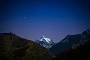Snowy mountain peak at night with the stars