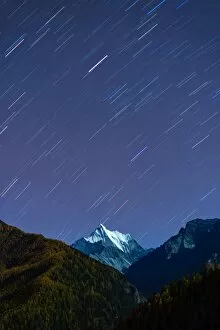 Snowy mountain peak and Star trail in Yading