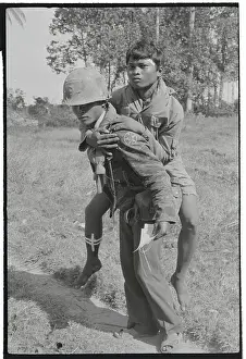 Soldier Carrying Injured Cambodian to Camp