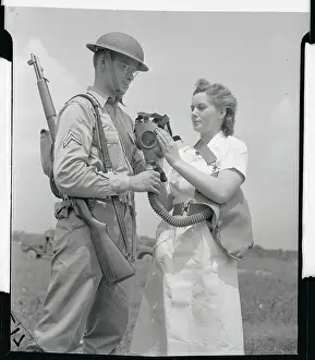 Soldier Explaining Gas Mask to Female Army Nurse