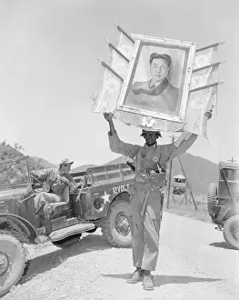 Soldier Holding Governmental Portrait While Transporting After Battle