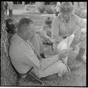 Little Rock Prints: Soldier Sitting on Ground with Newspaper