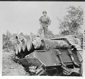 US Soldier Standing Atop Overturned Tank