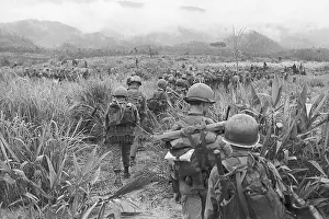 Backpack Prints: Soldiers Patrolling Through High Grass in Saigon