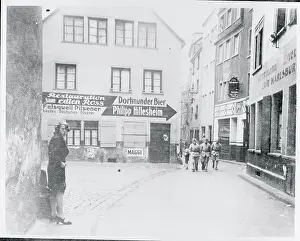 Soldiers Walking in Street Near Stores