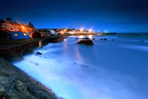 St Monans harbour lights at storm sea in night