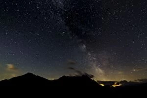 Starry sky with the Milky Way over a mountain landscape, with light pollution, Safien, Canton of Graubunden