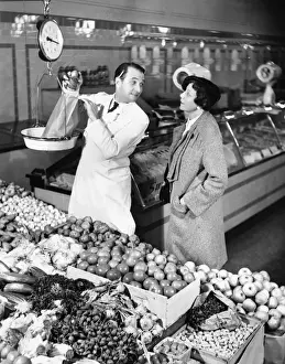 40 45 Years Prints: Store clerk weighing tomatoes for client (B&W)