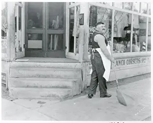 Commerce Prints: Store Owner Sweeping Sidewalk