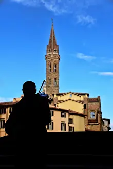Entertainment Occupation Prints: Street musician plays a violin in front of Badia Fiorentina bell-tower in Florence, Italy