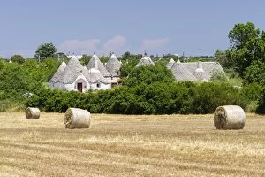 Images Dated 27th May 2014: Stubble field, straw bales, Trulli houses, traditional round houses, at the back, near Locorotondo