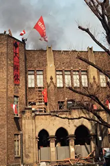 Student Waving Flag from Top of Building
