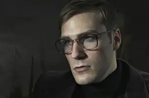 Introspection Prints: Student wearing a suit and glasses, sitting in front of a painting