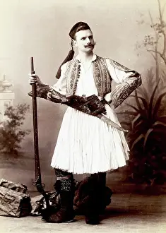 Culture Prints: Studio portrait of a man in traditional Greek dress with rifle and sword