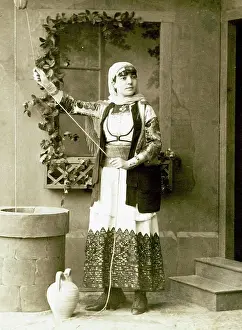 Direct Look Prints: Studio portrait of a woman in traditional Greek dress beside a fountain