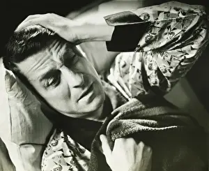 Worried Prints: Suffering man lying on bed, (B&W), close-up, elevated view