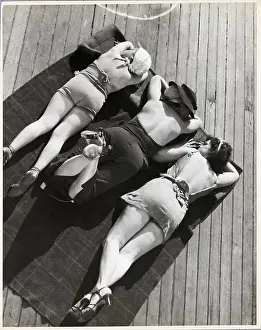 Sunbathing Prints: Three Sunbathers on Towel on Deck of Ship