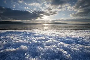 Lakeside Prints: Sunlight with moody clouds, stacked ice floes on the shore of Reichenau Island