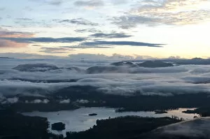 Cloudy Sky Collection: Sunrise over the mountains, cloudy sky above Maskeliya Reservoir, view from Adams Peak, Sri Pada