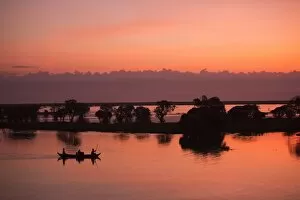 Sunrise sky over tonle sap lake and Fisherman fishing on the boat