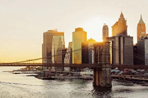 Suspension Bridge Gallery: Sunset over Brooklyn Bridge and skyline of Manhattan Financial District in Downtown