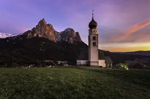 Sunset scenery of Church St. Valentin at Kastelruthand jagged rocks of Schlern background