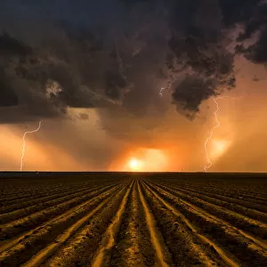 Lightning Storms Gallery: Sunset Thunderstorm over a ploughed field, Nebraska. USA