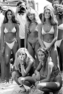 Prints of Competitors in the bikini contest at the Instinct Malibu US Pro Invitatiomal Surfing Contest line up on the beach with a photographer in their midst in 1981 in Malibu, California Timeless Moments: A Visual Journey Through History’s Defining Images: Surf and Bikini Contest