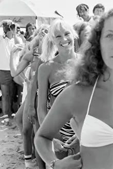 Prints of Malibu resident Kathy Schindler smiles at the camera wearing a Norma Kamali swimsuit in a line of bikini contest competitors at the Instinct Malibu US Pro Invitational Surf Contest on the beach Timeless Moments: A Visual Journey Through History’s Defining Images: Surf and Bikini Contest
