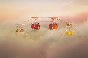 Surreal picture of colorful ferris wheel emerging from the clouds