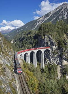 Switzerland, red train on a Viaduct