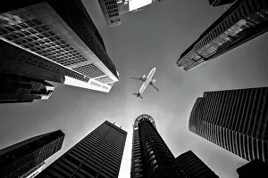 Buildings Collection: Tall city buildings and a plane flying overhead