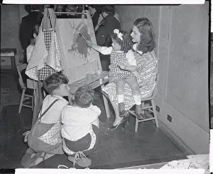 Teacher Holding Child Making Painting
