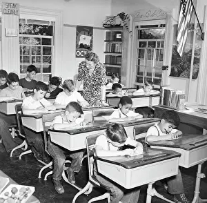 Teacher Supervises Students Taking Quiz at One Room School
