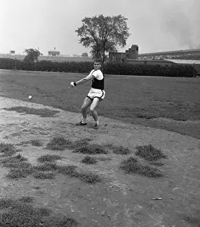 Teenage boy (13-14) swinging hammer on field, (B&W)