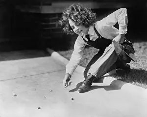 Pre Teen Girl Prints: Teenage girl (13-15 years) playing marbles on pavement