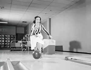 Bowling Alley Prints: Teenage girl releasing bowling ball into alley, friend looking on in background