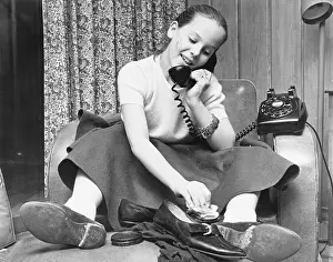 Polishing Prints: Teenage Girl Talks on Phone While Polishing Shoes