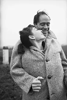 Prints of American actor Mel Ferrer (1917 - 2008) buttons up his coat around his wife, actress Audrey Hepburn (1929-1993), on a country road outside Paris, 1956 Elegance Personified – A Classic Art Print Collection: Tender Moment