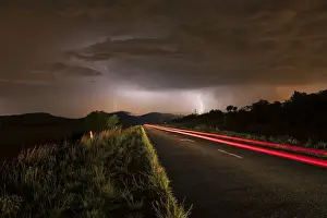 A thunderstorm at night with lightning on a remote road in the Cradle of Humankind, Magaliesburg, Gauteng Province, South Africa