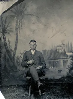 Time Captured: Vintage Art: Tintype portrait of young man in portrait studio with tropical painted backdrop
