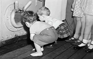 Toddlers Gazing Through Porthole On Ship