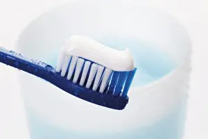 Studio Prints: Toothbrush with toothpaste in front of a toothbrush tumbler with mouthwash