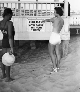 Sunbathing Prints: Topless Bather Pointing to Sign on Beach