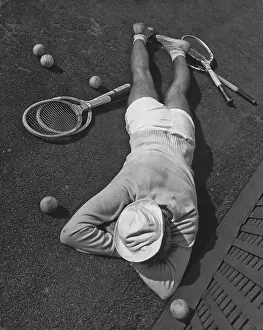Prints of A tennis player lying face down on the clay court at the West Side Tennis Club in Forest Hills, New York in 1939. (Photo by Max Peter Haas/FPG/Getty Images) The Grand Slam Gallery: A Tough Game Of Tennis