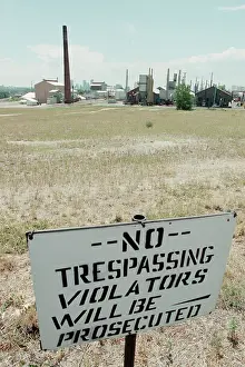 No Trespassing Sign In Field By Factory