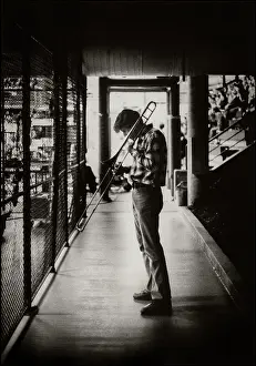 Prints of View of a musician playing a trombone the grandstand during halftime at a Santa Clara University basketball game, Santa Clara, California, 1980. (Photo by Bromberger Hoover Photography/Getty Images) Courtside Vibes: Stunning Basketball Prints: Trombone Player At Halftime