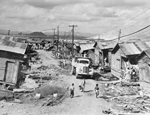 Pity Prints: Truck Entering Shambled Slum Area