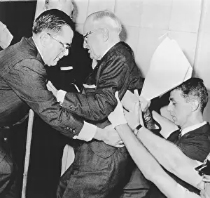 Truman falling and being helped by two men