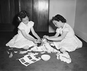 6 7 Years Prints: Twins (6-7) playing with doll, Chicago, Illinois, USA